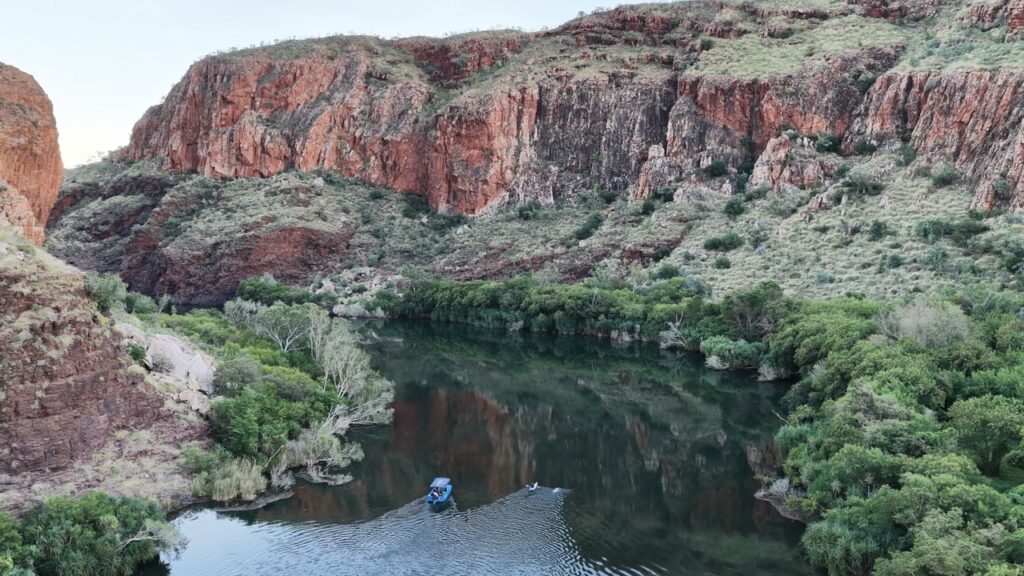 the Ord River flanked by gorges with a small boat and a swimmer. Andy Donaldson.